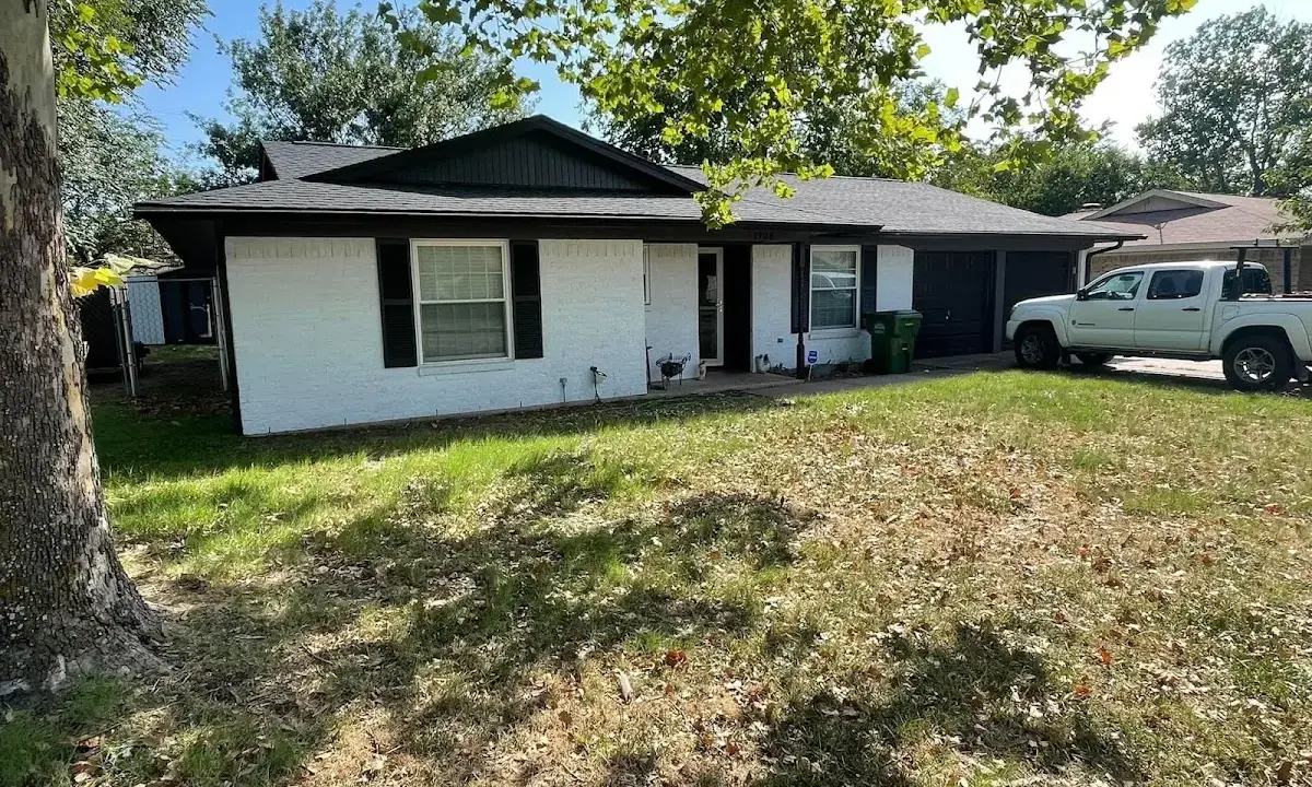 Professional roofing crew working on a residential roof in Cameron